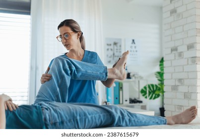 Physiotherapist doing manual therapy, exercise with teenage boy's knee, rehabilitation. Orthopedist examining and treating painful injured knee of young athlete. Concept of preventive health care for - Powered by Shutterstock