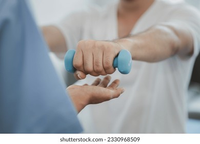 Physiotherapist doing physiotherapy for patient in a hospital room, physiotherapy helps to recover from illness by moving the body and muscles. The concept of treating illnesses with physical therapy. - Powered by Shutterstock