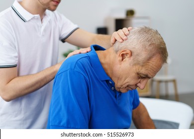 Physiotherapist examining an elderly male patient stretching and re-aligning his neck and vertebrae, close up upper body - Powered by Shutterstock