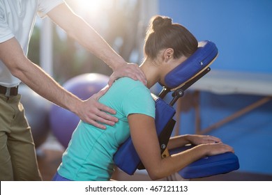 Physiotherapist giving back massage to a female patient in the clinic