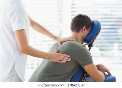 Physiotherapist giving back massage to man in hospital