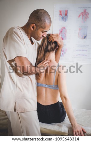 Physiotherapist giving back massage to a patient in clinic