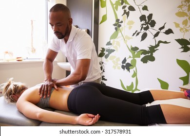 Physiotherapist Giving Female Patient Massage In Hospital