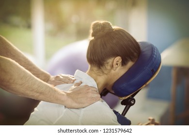 Physiotherapist giving shoulder massage to a female patient in the clinic