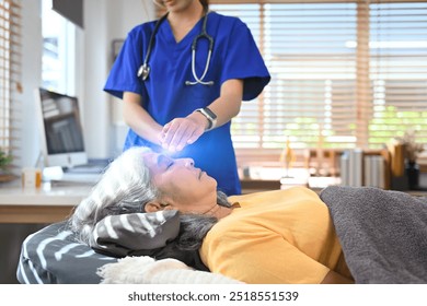 Physiotherapist or healer doing Reiki treatment session to mature woman at clinic. Alternative medicine concept - Powered by Shutterstock