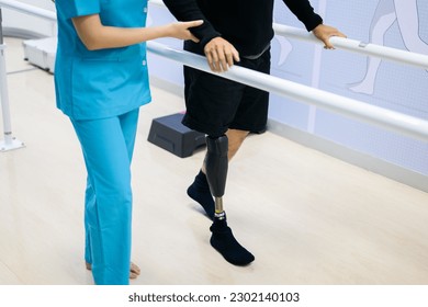 Physiotherapist helping patient with prosthetic leg at parallel bars - Powered by Shutterstock