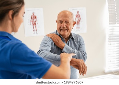 Physiotherapist helping senior man with elbow exercise in clinic. Doctor checking elbow of senior patient. Old man during an appointment with professional osteopath working and massaging his shoulder. - Powered by Shutterstock