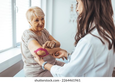 Physiotherapist helping senior woman with elbow exercise in clinic. Chiropractic checking elbow and shoulder joint pain of old patient. Woman undergoing physiotherapy treatment for shoulder injury - Powered by Shutterstock