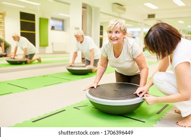 Physiotherapist Helps Senior Woman With Fitness Training With The Bosu Ball In The Gym