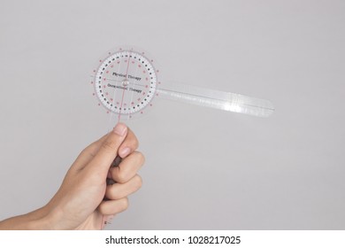 Physiotherapist Holding A Goniometer For Measuring Range Of Motion Isolated On White Background.