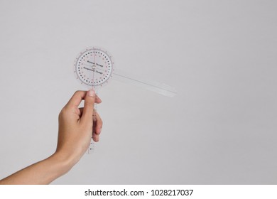 Physiotherapist Holding A Goniometer For Measuring Range Of Motion Isolated On White Background.