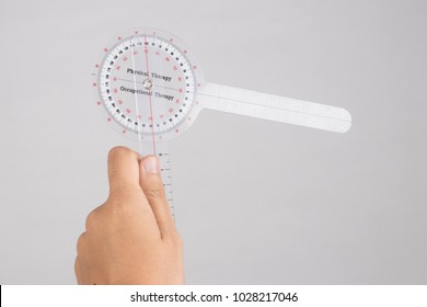 Physiotherapist Holding A Goniometer For Measuring Range Of Motion Isolated On White Background.