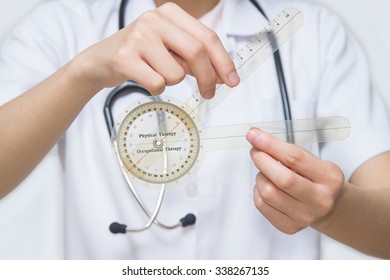 Physiotherapist  Holding  A Goniometer For Measuring Range Of Motion