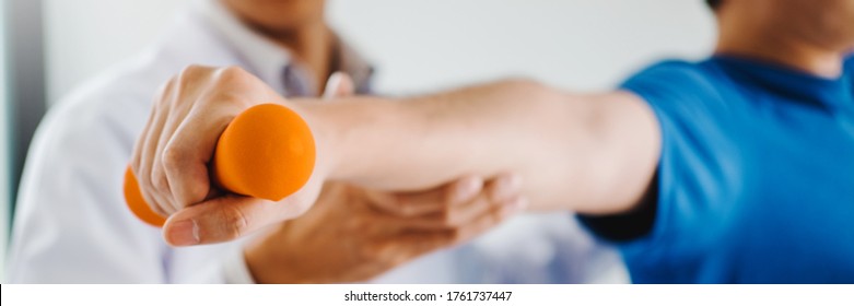 Physiotherapist man giving exercise with dumbbell treatment About Arm and Shoulder of athlete male patient Physical therapy concept - Powered by Shutterstock