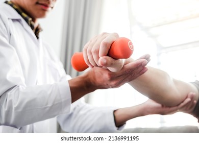 Physiotherapist man giving exercise with dumbbell treatment About Arm and Shoulder of athlete male patient Physical therapy concept - Shutterstock ID 2136991195