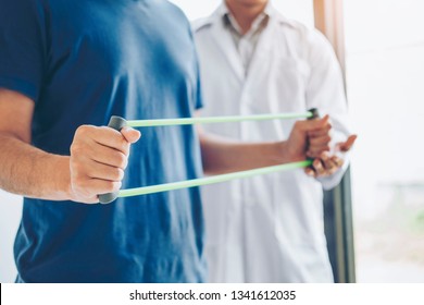 Physiotherapist man giving resistance band exercise treatment About Chest muscles and Shoulder of athlete male patient Physical therapy concept - Powered by Shutterstock