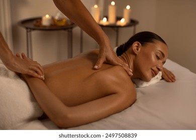 Physiotherapist massaging female patient with damaged scapula muscle, treating sports injuries in cozy atmosphere, reboot on the weekend - Powered by Shutterstock