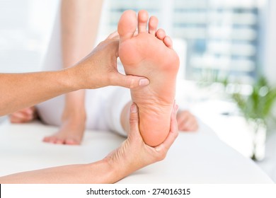 Physiotherapist Massaging Her Patients Foot In Medical Office