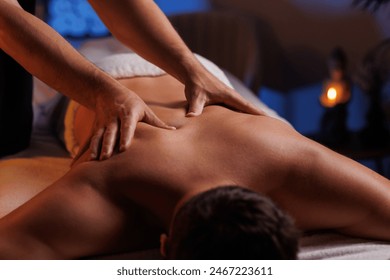 Physiotherapist massaging male patient with damaged shoulder muscle, treating sports injuries. Relaxing professional shoulder massage in cozy atmosphere, reboot on the weekend, end of difficult week. - Powered by Shutterstock