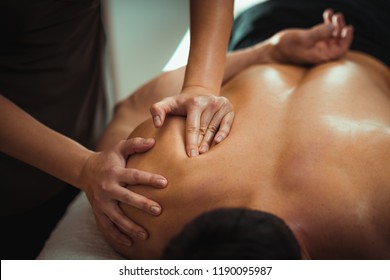 Physiotherapist Massaging Male Patient With Injured Shoulder Blade Muscle. Sports Injury Treatment.