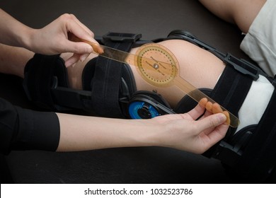 Physiotherapist Measuring Range Of Motion On Patients' Knee With Goniometer