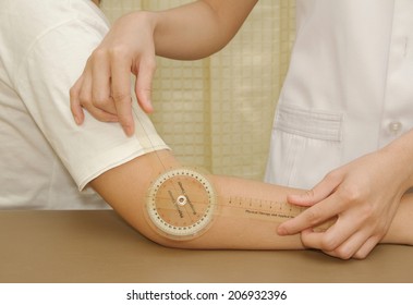 Physiotherapist Measuring Range Of Motion Patients' Elbow With Goniometer