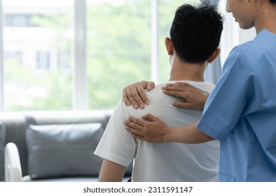 A physiotherapist or medical professional doing physiotherapy on the back scapula and back injury of male athlete patient stretching and exercise cause pain rehabilitation therapy, health insurance. - Powered by Shutterstock