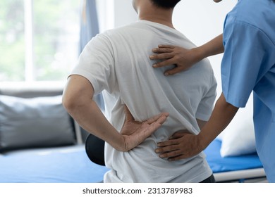 A physiotherapist or medical professional doing physiotherapy on the back scapula and back injury of male athlete patient stretching and exercise cause pain rehabilitation therapy, health insurance. - Powered by Shutterstock