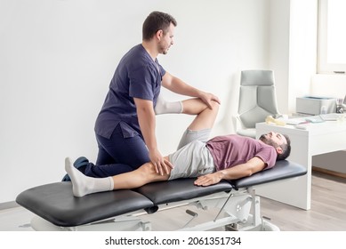 Physiotherapist performing mobility exercises on the leg of a patient lying on a stretcher - Powered by Shutterstock