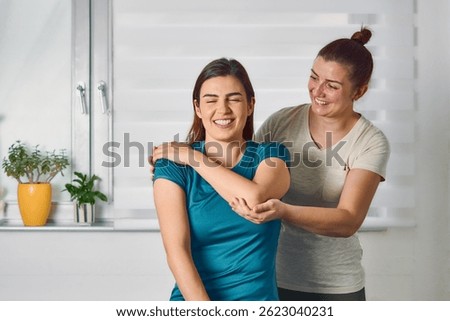  Physiotherapist practicing chiropractic techniques on a young adult woman patient.Young woman with rheumatological problem getting professional doctor's help.                              