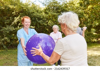 Physiotherapist and seniors do an exercise with the exercise ball in a garden - Powered by Shutterstock