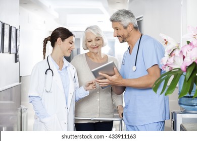 Physiotherapist Showing Reports To Patient And Doctor On Tablet 