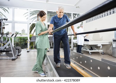 Physiotherapist Standing By Smiling Patient Walking Between Para - Powered by Shutterstock