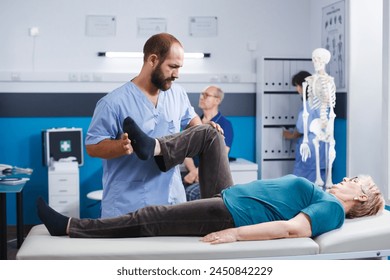 Physiotherapist stretching leg muscle to relieve pressure for recovery of senior woman. Doctor assistant helping aged patient with knee pain, doing physical exercise for physical therapy. - Powered by Shutterstock