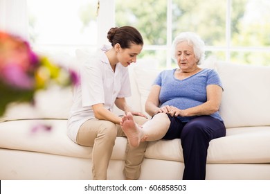 Physiotherapist taking care of sick elderly patient at home - Shutterstock ID 606858503