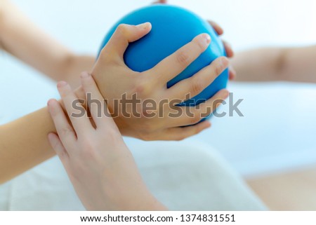 Physiotherapist trains with a Pilates ball