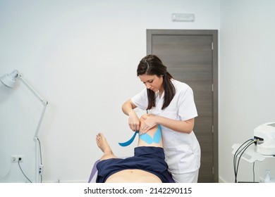 physiotherapist treating the patient's knee with neuromuscular taping - Powered by Shutterstock