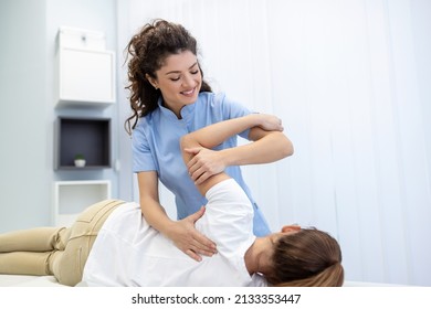 Physiotherapist Treatment Patient. Holding Patient's Hand, Shoulder Joint Treatment. Physical Doctor Consulting With Patient About Shoulder Muscule Pain Problems Physical Therapy Diagnosing Concept