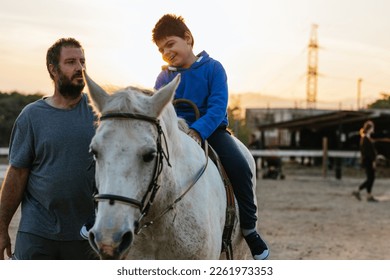 Physiotherapist working with a child with a disability in an equine therapy session.