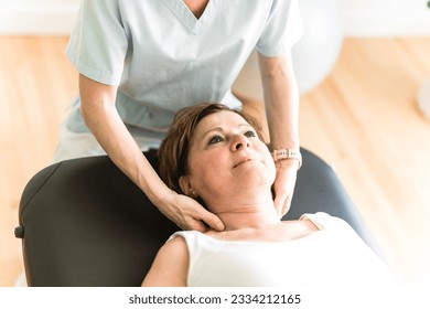 A Physiotherapist working with elderly patient in clinic - Powered by Shutterstock