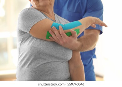 Physiotherapist working with elderly patient in clinic - Powered by Shutterstock