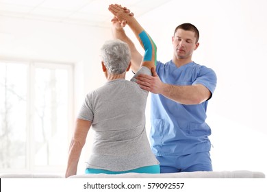 Physiotherapist working with elderly patient in clinic - Powered by Shutterstock