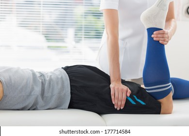 Physiotherapist working on the leg of young man