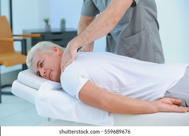 Physiotherapist Working With Patient In Clinic