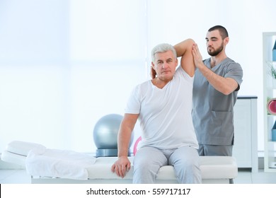 Physiotherapist working with patient in clinic - Powered by Shutterstock