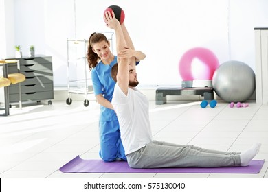 Physiotherapist Working With Patient In Clinic