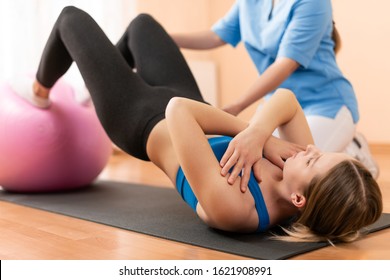 Physiotherapist working with young female client on core strength using fitball. Rehabilitation and physiotherapy background. - Powered by Shutterstock