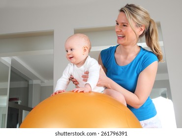 A Physiotherapy With Baby On A Fitness Ball