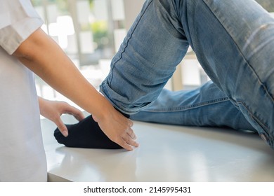 Physiotherapy Concept Image Of A Young Man With Injured Leg Giving Doctor Massage Patient Leg Giving Medical Treatment For Sprained Ligament The Concept Of Rehabilitation After A Leg Injury.