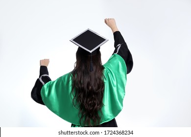 Physiotherapy Or Nursing Student, From The Back, With Her Hands Raised, Wearing A Black Dress With A Cap And A Cape And Green Belt.
